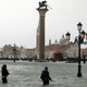 People walk in flooded Saint Mark Square during a period of seasonal high water in Venice